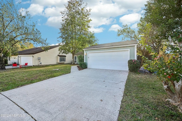 single story home with a front lawn, an outdoor structure, and a garage