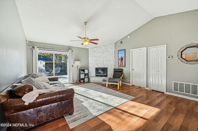 living room with hardwood / wood-style floors, ceiling fan, a fireplace, and a textured ceiling