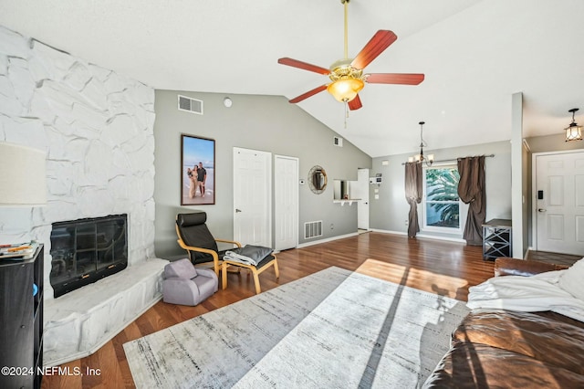 living room with ceiling fan with notable chandelier, lofted ceiling, and dark wood-type flooring