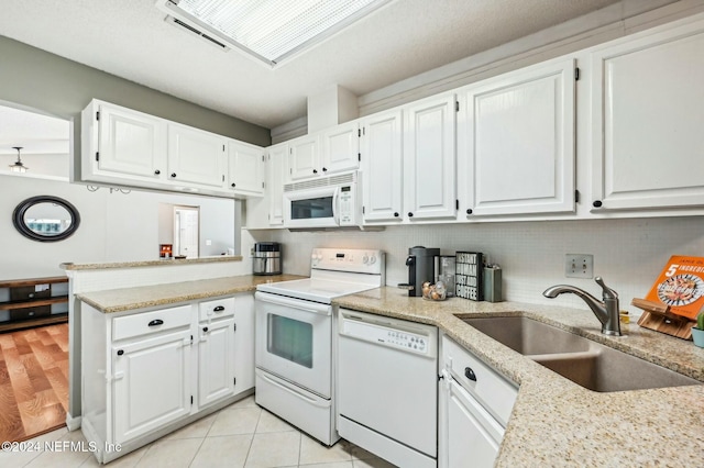 kitchen featuring white appliances, white cabinetry, and sink