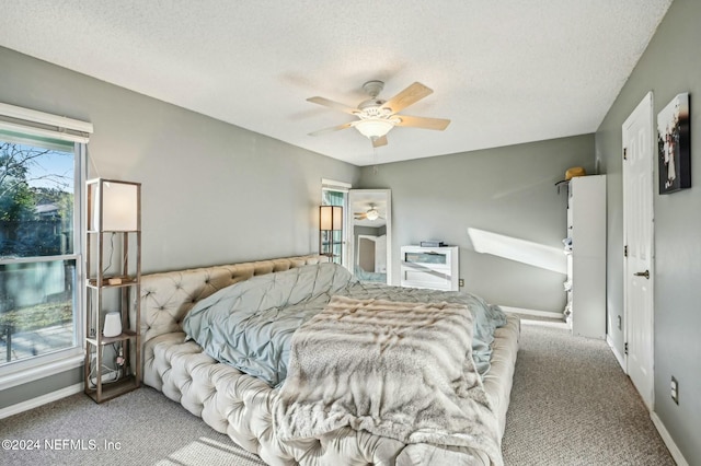 bedroom with carpet, ceiling fan, and a textured ceiling