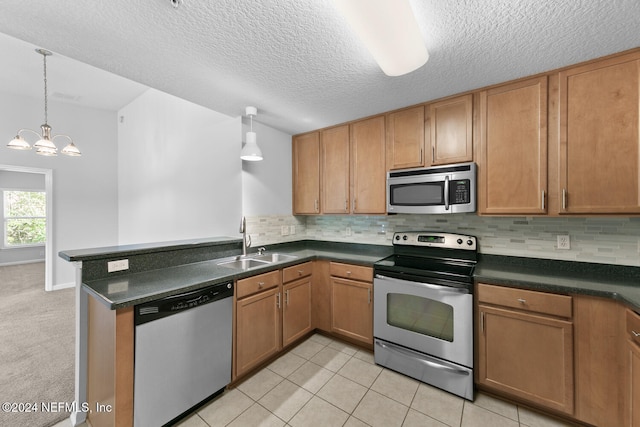 kitchen with light tile patterned flooring, stainless steel appliances, a notable chandelier, and sink