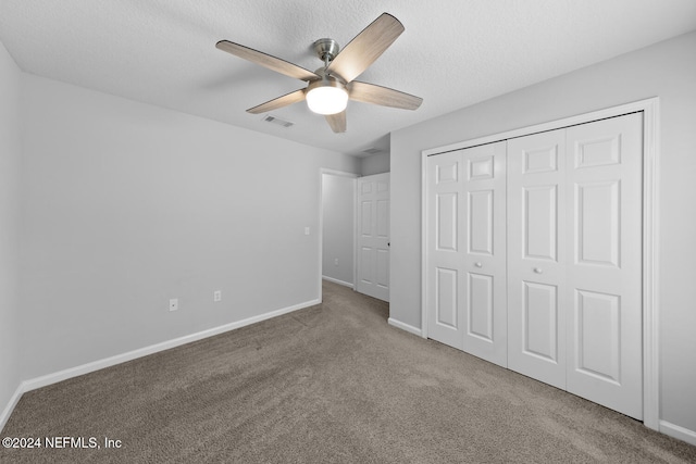 unfurnished bedroom featuring carpet flooring, a textured ceiling, a closet, and ceiling fan