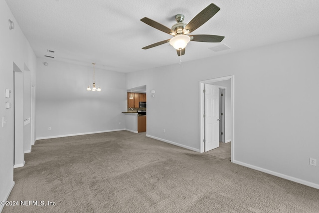 unfurnished room with light carpet, a textured ceiling, and ceiling fan with notable chandelier