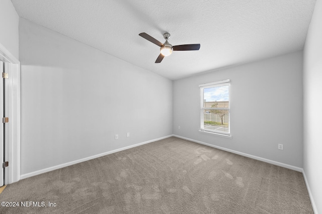 carpeted empty room featuring ceiling fan and a textured ceiling