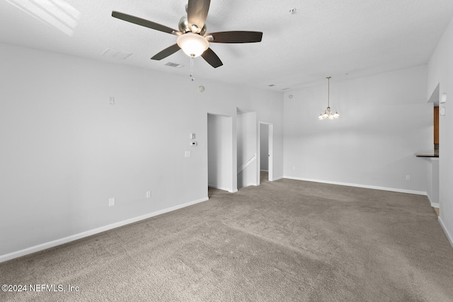 carpeted spare room featuring ceiling fan with notable chandelier