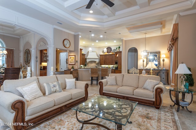 living room featuring decorative columns, ceiling fan, a towering ceiling, and ornamental molding