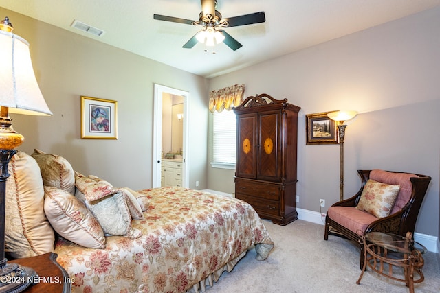 bedroom with ensuite bathroom, ceiling fan, and light colored carpet