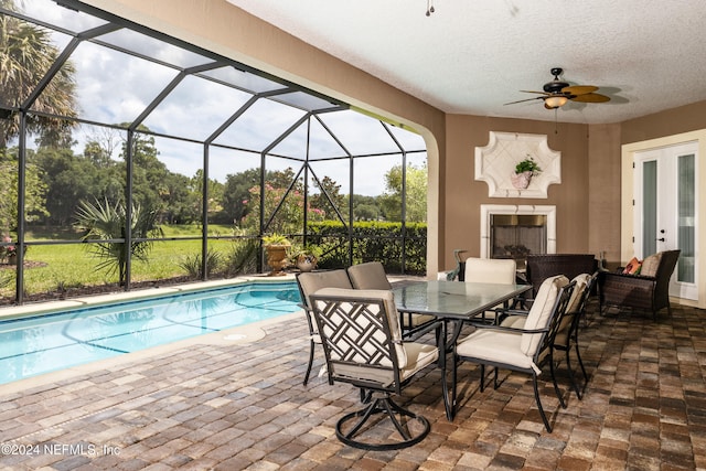 view of pool with ceiling fan, a patio area, a lanai, and an outdoor living space