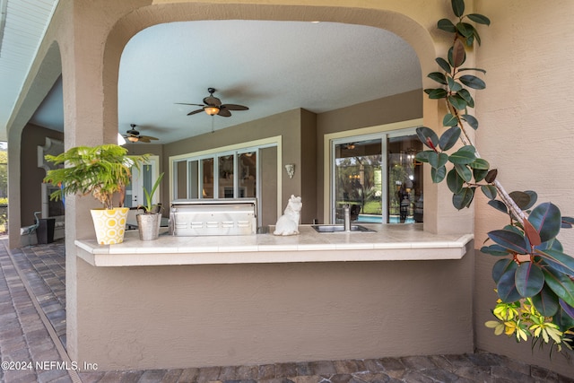 view of patio with ceiling fan and sink