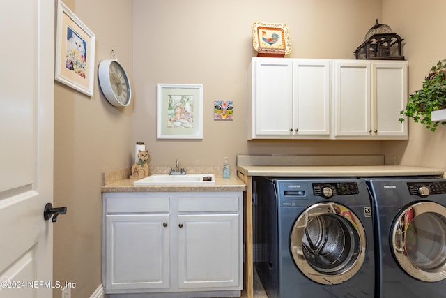 washroom featuring cabinets, sink, and washer and dryer