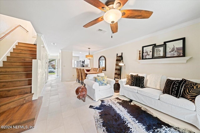 living room with light tile patterned floors, ceiling fan with notable chandelier, and ornamental molding