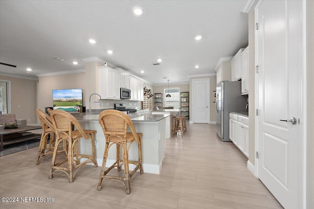 kitchen with kitchen peninsula, white cabinetry, stainless steel appliances, and a breakfast bar area