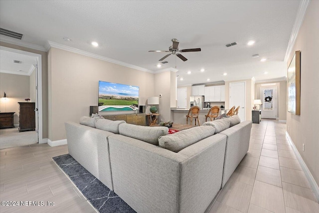 tiled living room with ceiling fan, crown molding, and a wealth of natural light