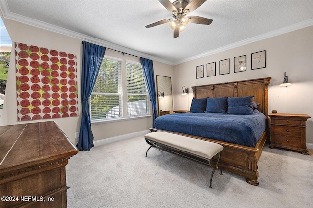 carpeted bedroom with a textured ceiling, ceiling fan, and crown molding