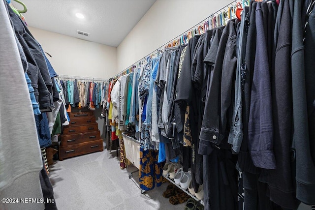 walk in closet featuring light carpet