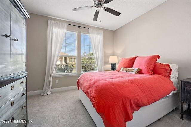 carpeted bedroom featuring a textured ceiling and ceiling fan