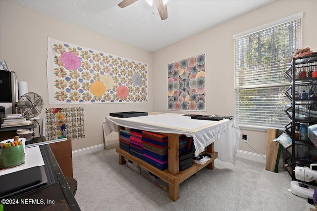 bedroom featuring a textured ceiling, light colored carpet, and ceiling fan