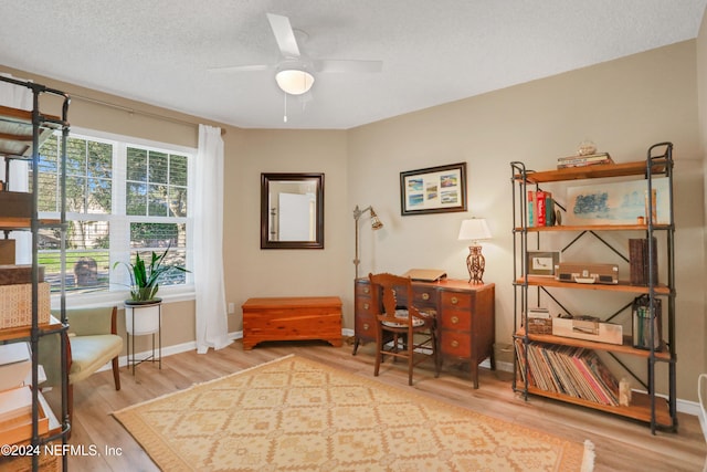 home office featuring hardwood / wood-style floors, ceiling fan, and a textured ceiling