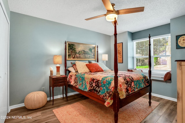 bedroom with hardwood / wood-style floors, ceiling fan, a textured ceiling, and a closet