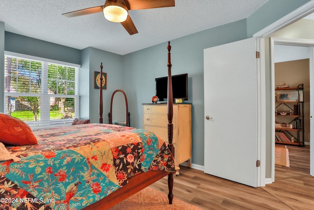 bedroom featuring ceiling fan, light hardwood / wood-style flooring, and a textured ceiling