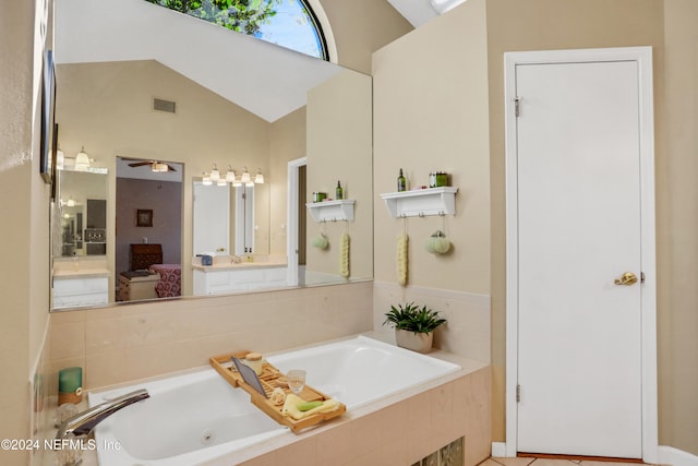 bathroom featuring a relaxing tiled tub, ceiling fan, vanity, and vaulted ceiling