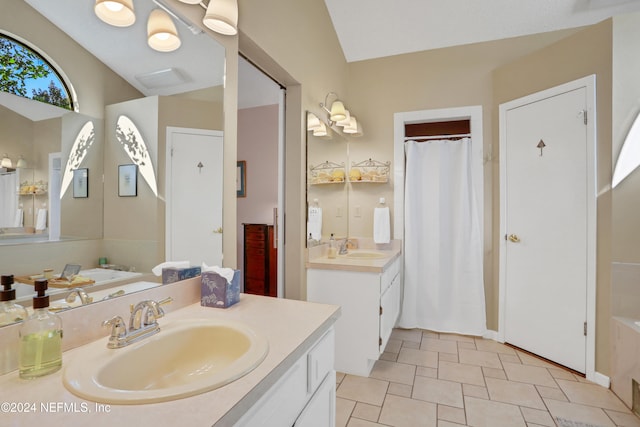 bathroom featuring a bathing tub, vanity, and vaulted ceiling