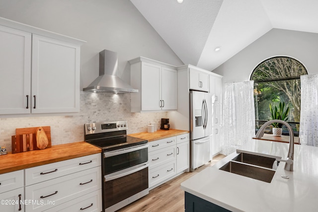 kitchen featuring white cabinetry, sink, wall chimney range hood, and appliances with stainless steel finishes