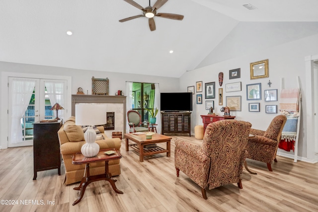 living room featuring ceiling fan, light hardwood / wood-style floors, high vaulted ceiling, and french doors