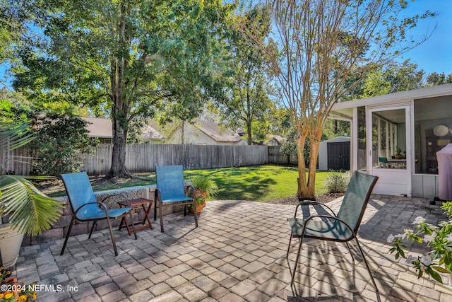 view of patio with a sunroom and a shed