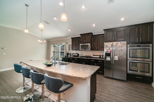 kitchen with ornamental molding, appliances with stainless steel finishes, lofted ceiling, and a sink