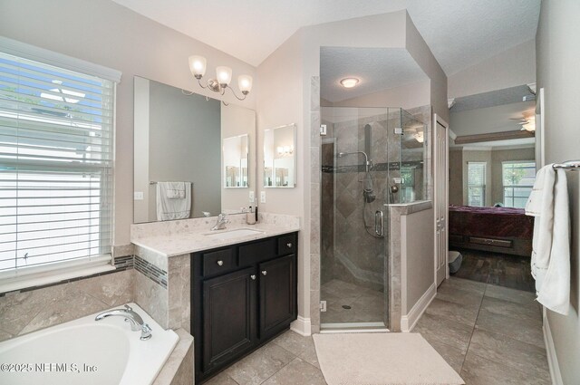 bathroom featuring a stall shower, ensuite bath, a bath, vanity, and vaulted ceiling