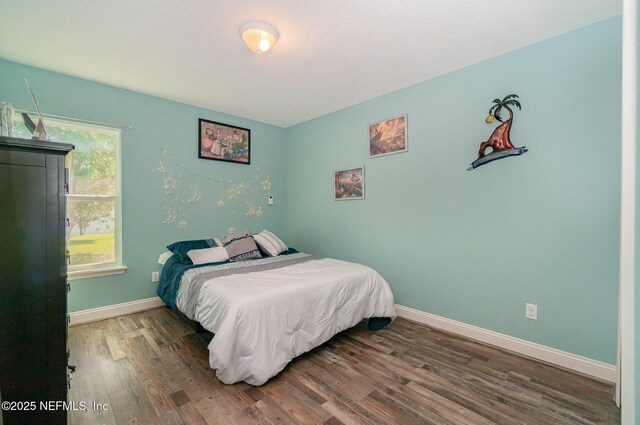 bedroom featuring wood finished floors and baseboards