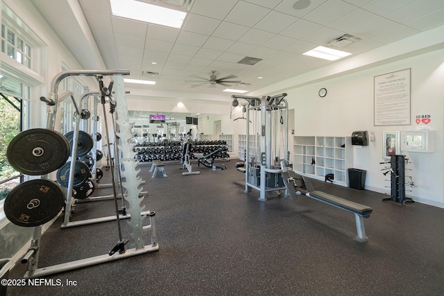 exercise room featuring a ceiling fan, baseboards, visible vents, and a drop ceiling