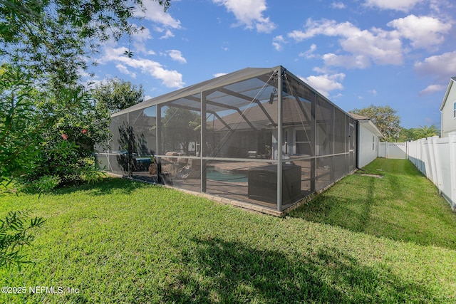 back of house featuring a lanai, a lawn, a fenced backyard, and a fenced in pool