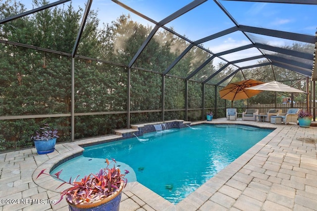 view of pool featuring glass enclosure, pool water feature, and a patio