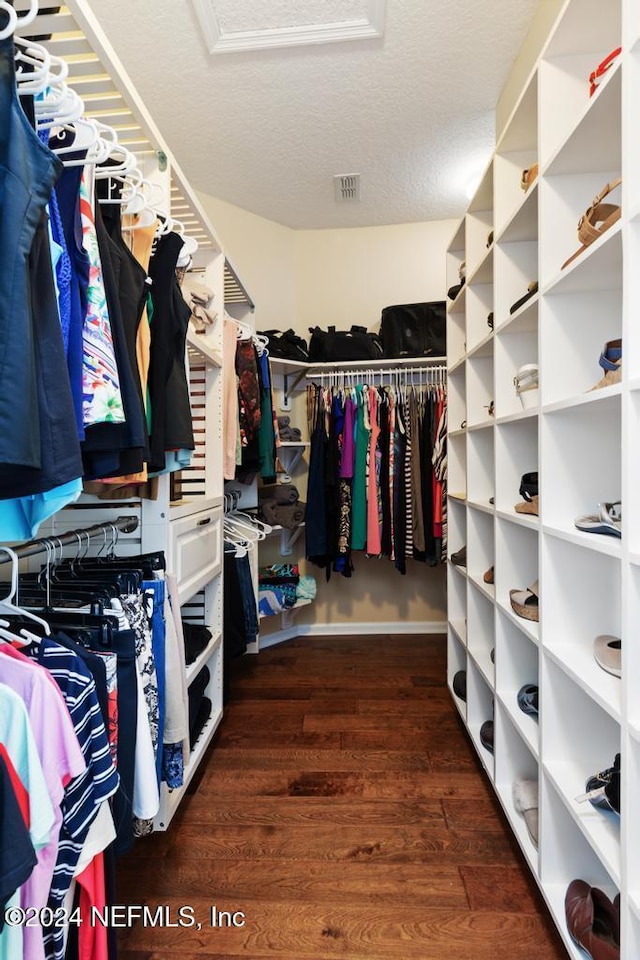 spacious closet featuring dark hardwood / wood-style flooring