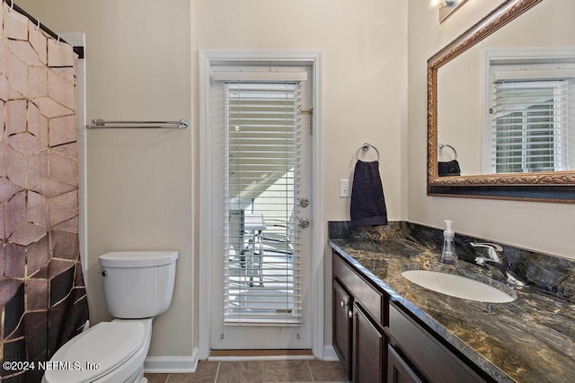 bathroom with tile patterned flooring, vanity, and toilet