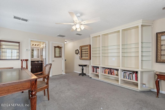 carpeted office space featuring ceiling fan