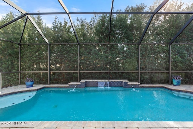 view of pool with glass enclosure and pool water feature