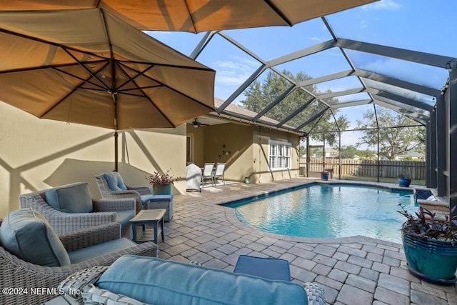 view of pool with a patio area and glass enclosure