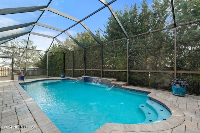 view of pool featuring pool water feature, glass enclosure, and a patio area