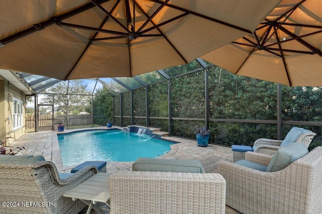 view of pool featuring pool water feature, glass enclosure, and a patio area