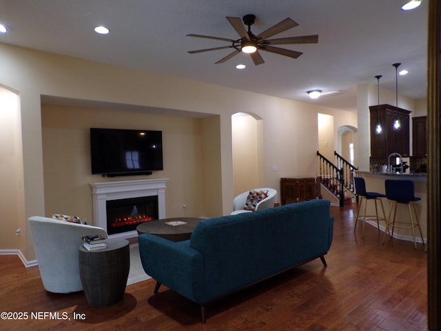 living room featuring dark hardwood / wood-style flooring and ceiling fan