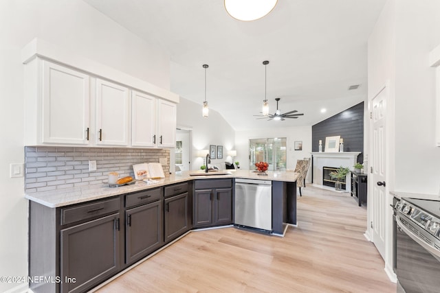 kitchen featuring kitchen peninsula, stainless steel appliances, sink, white cabinetry, and lofted ceiling