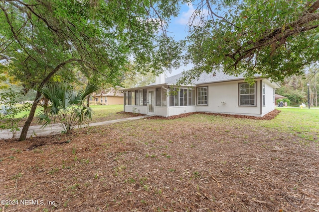 view of front of property with a front lawn and a sunroom