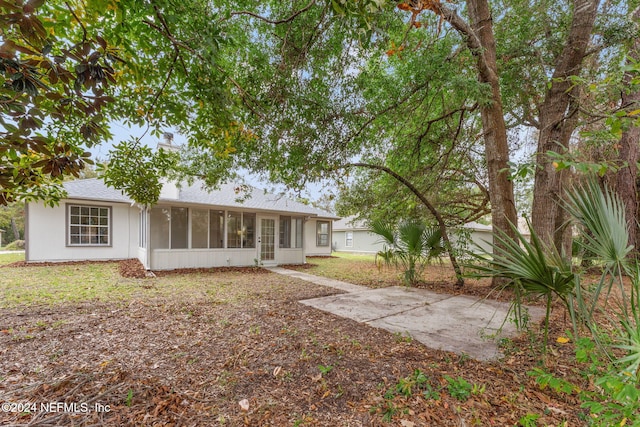 rear view of property featuring a sunroom