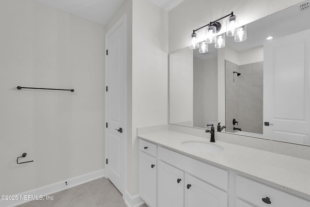 full bathroom featuring vanity, tile patterned floors, tiled shower, and baseboards