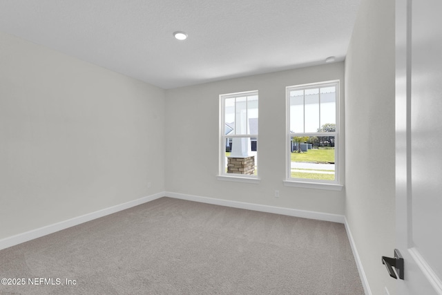 unfurnished room with carpet flooring and baseboards
