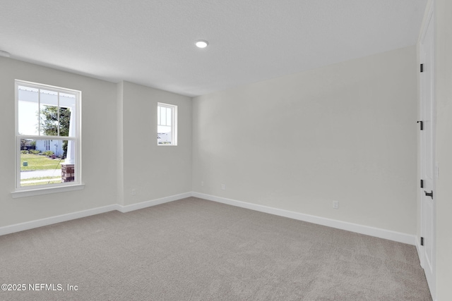 spare room featuring carpet, baseboards, and recessed lighting